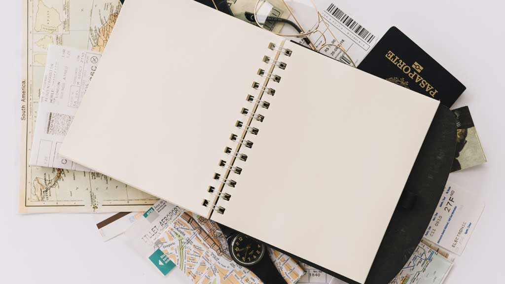 Seguro Viagem Nacional 4 Imagem de um caderno com passaporte para ilustrar o tópico como contratar seguro viagem nacional