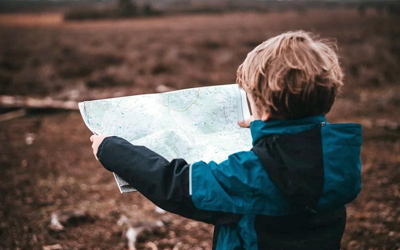 Viajar com crianças: destinos e dicas para ter uma viagem segura e tranquila 1 Criança com um mapa na mão