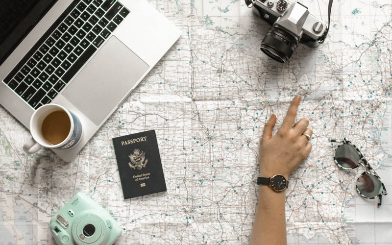 Fronteiras abertas para brasileiros: confira todos os países que brasileiros podem viajar 2 Imagem de uma pessoa planejando o roteiro da viagem em cima do mapa