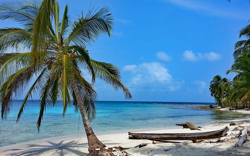 Quarentena no exterior: onde fazer quarentena para entrar nos EUA 6 Isla Diablo San Blas, praia com coqueiro e barco.
