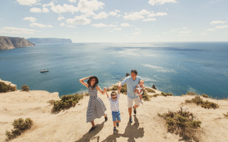 Seguro Viagem: Quais Coberturas Estão Disponíveis para Você? 1 Familia visitando o mar em cima de uma montanha.
