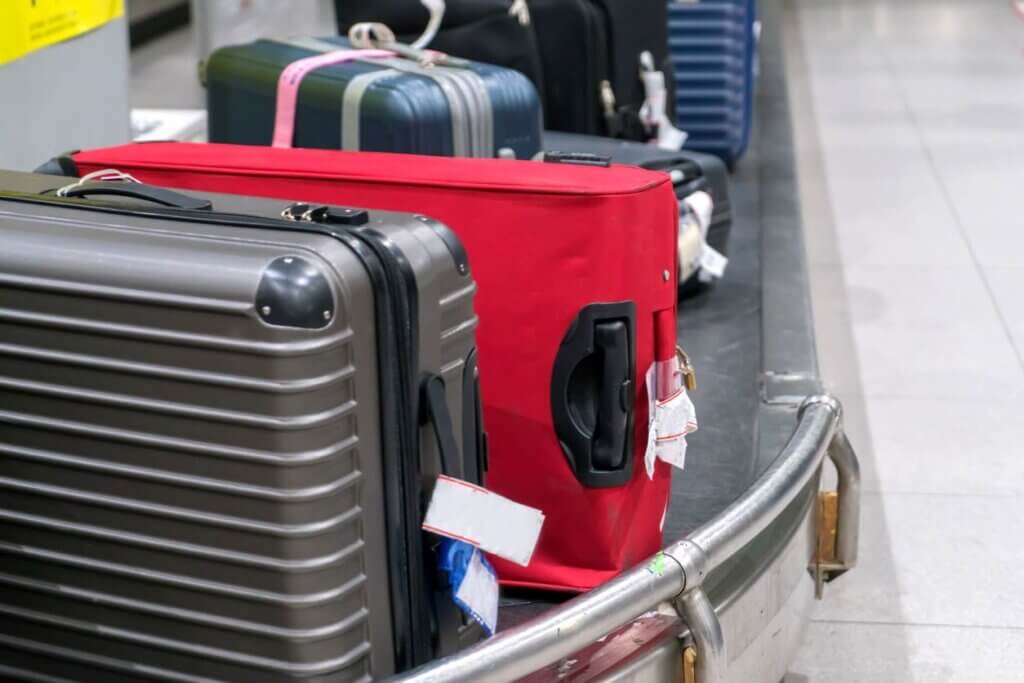 Mala extraviada: o que fazer para localizar a bagagem e acionar o seguro 3 Malas sob a esteira de um aeroporto.