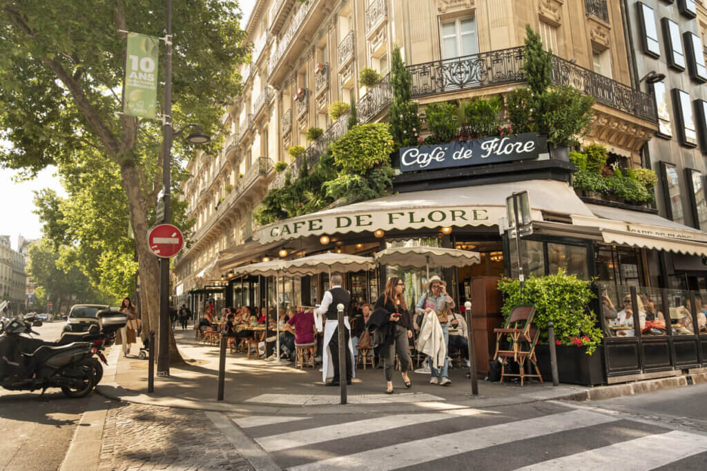 Custo de viagem para Paris em 2026: quanto levar e como planejar 2 Restaurante de café ao ar livre do pátio de Paris France no bairro histórico de St Germain com árvores ao redor