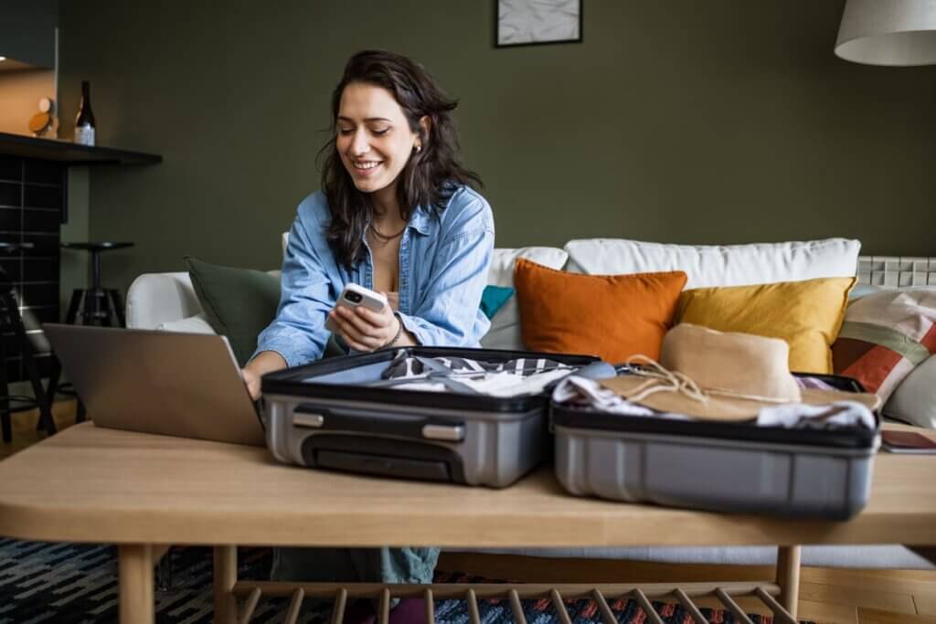 Checklist para viajar completo para viagens nacionais e internacionais 1 Mulher usando laptop para programar viagem