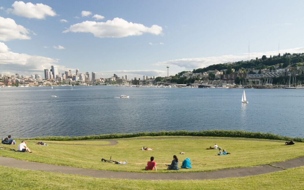 Pessoas na grama com céu ensolarado no verão no Lake Union, em Seattle