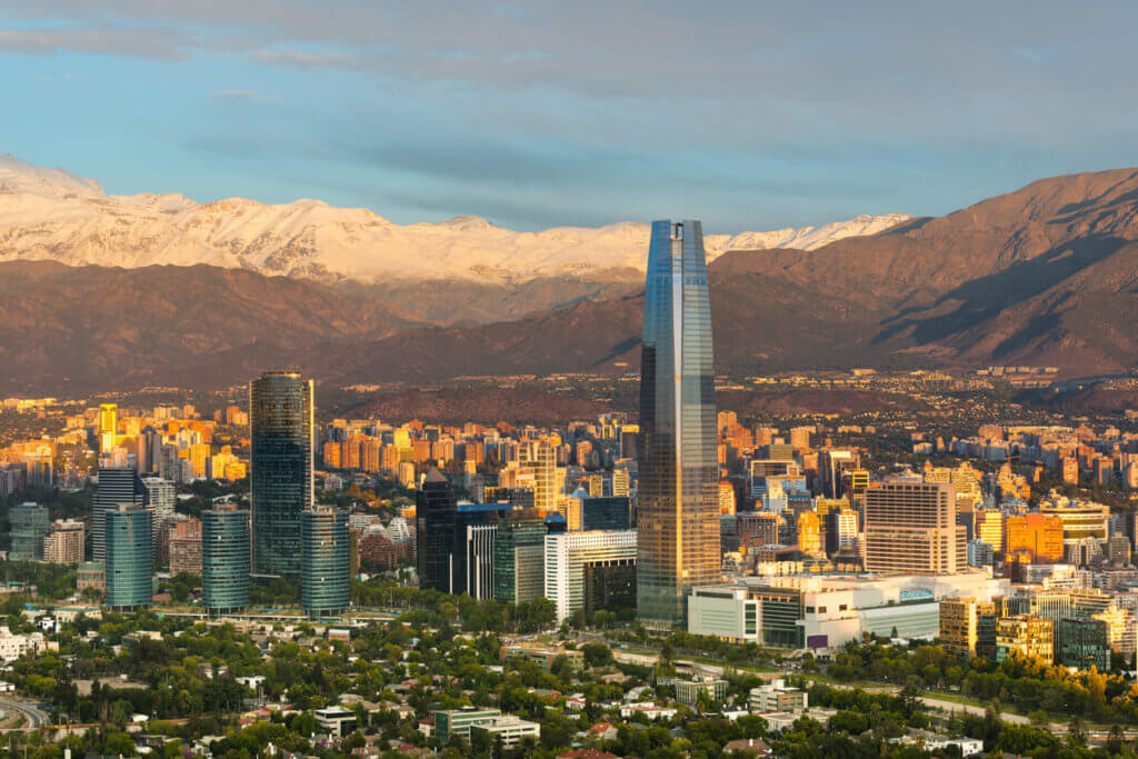 Custo de viagem para o Chile em 2026: quanto levar e como planejar 1 Vista da cidade de Santiago, Chile, com montanhas ao fundo durante o pôr do sol