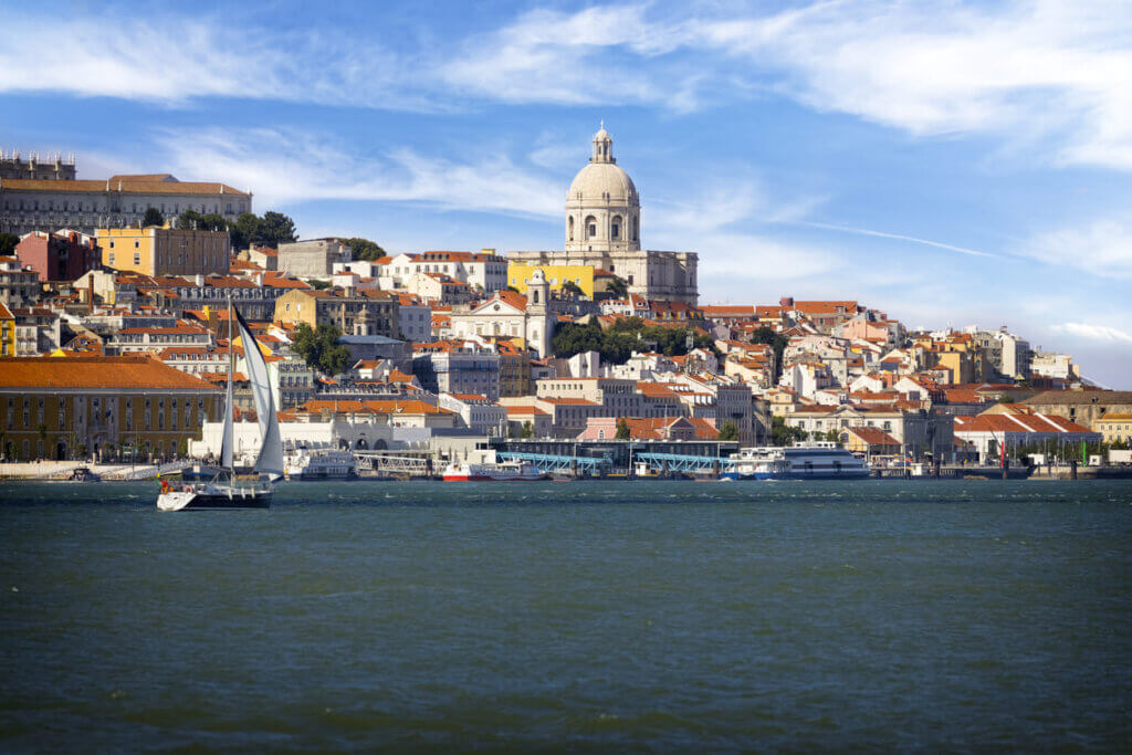 Quanto custa uma viagem para Portugal: orçamento detalhado por categoria 1 Vista da cidade de Lisboa com um rio e céu ensolarado