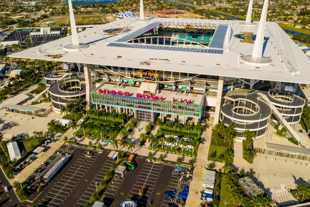Estádio Hard Rock no Miami Dolphins, destino perfeito para eventos esportivos e shows ao vivo, com arquibancadas modernas, área de estacionamento ampla e arquitetura futurista.